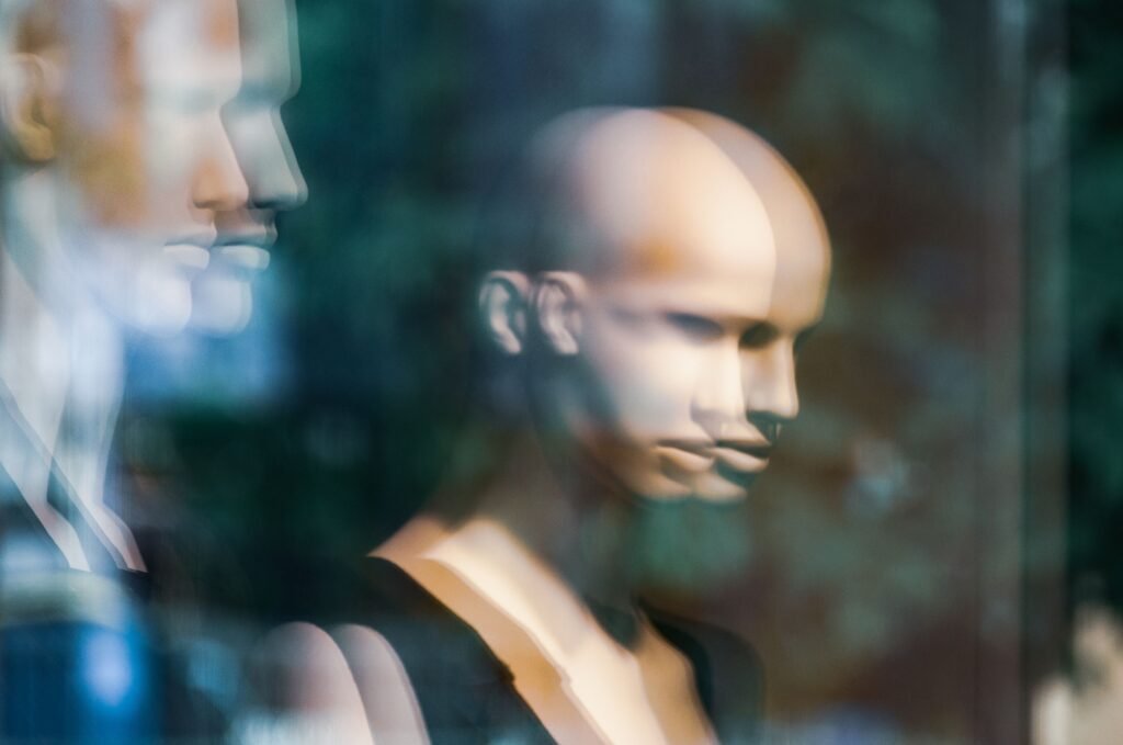 Can You Trademark Your Name, Image, and Likeness 2 Blurred reflection of mannequins in a storefront window creates an abstract artistic effect.